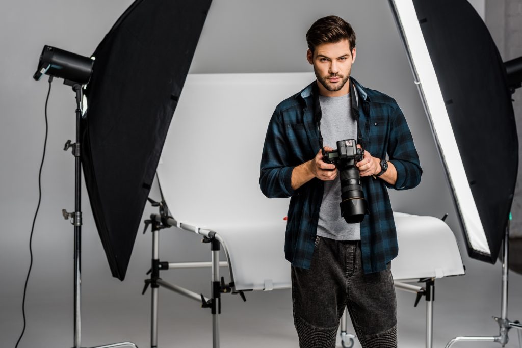 Inicio 2 handsome professional young photographer using camera in photo studio