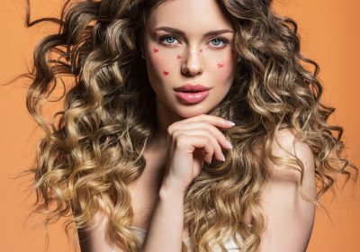 Portrait of a beautiful girl with painted red hearts on her face. Fashion photography. Sexy blonde. Portrait of a beautiful girl with painted red hearts on her face. Fashion photography. Sexy blonde.